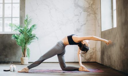 Woman performing yoga pose indoors, embracing mindfulness and flexibility.